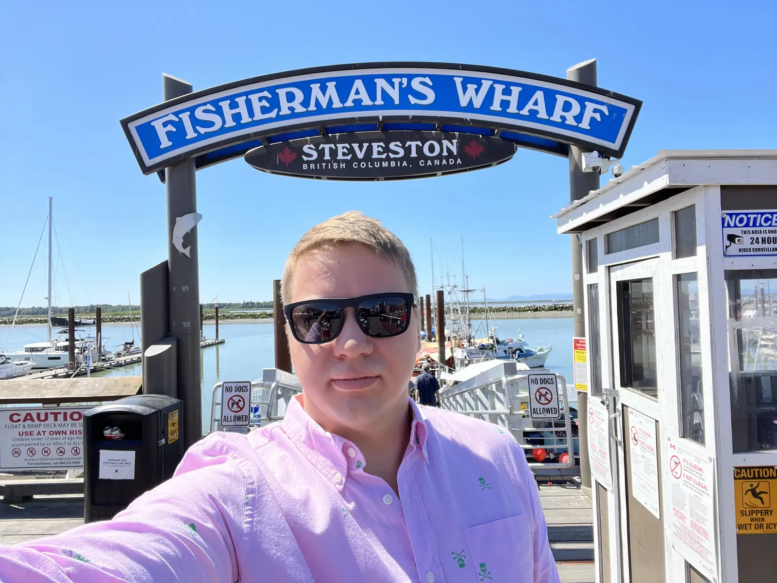 A WP Support BC team member at Fisherman's Wharf in Steveston, British Columbia, with the marina and boats behind him